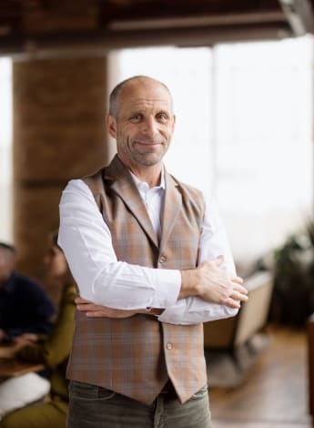 The image is of a confident man smiling at the camera. 